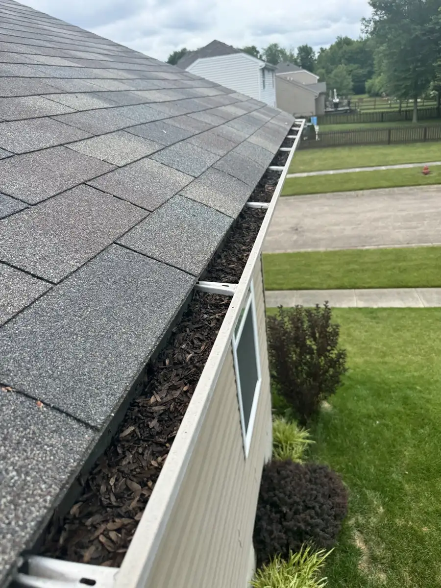 Clogged residential gutter packed with leaves and debris before cleaning by Skyline